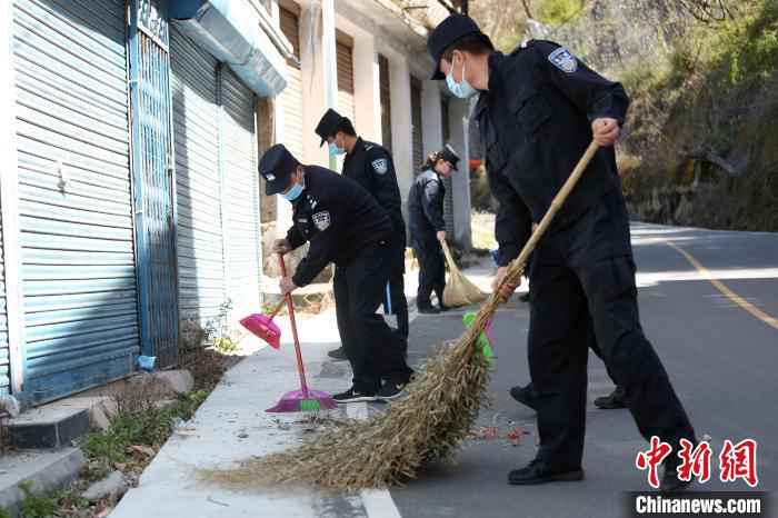图为边检站民警清扫路边垃圾。 邹兴国 摄 中尼边境樟木口岸开展爱国卫生运动 助力疫情防控